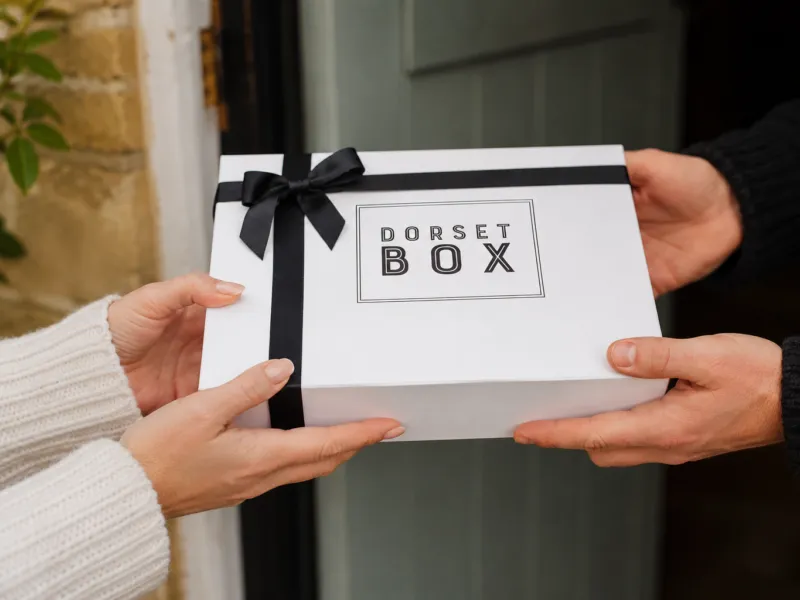 Hands handing over a Dorset Box Hands handing over a Dorset Box