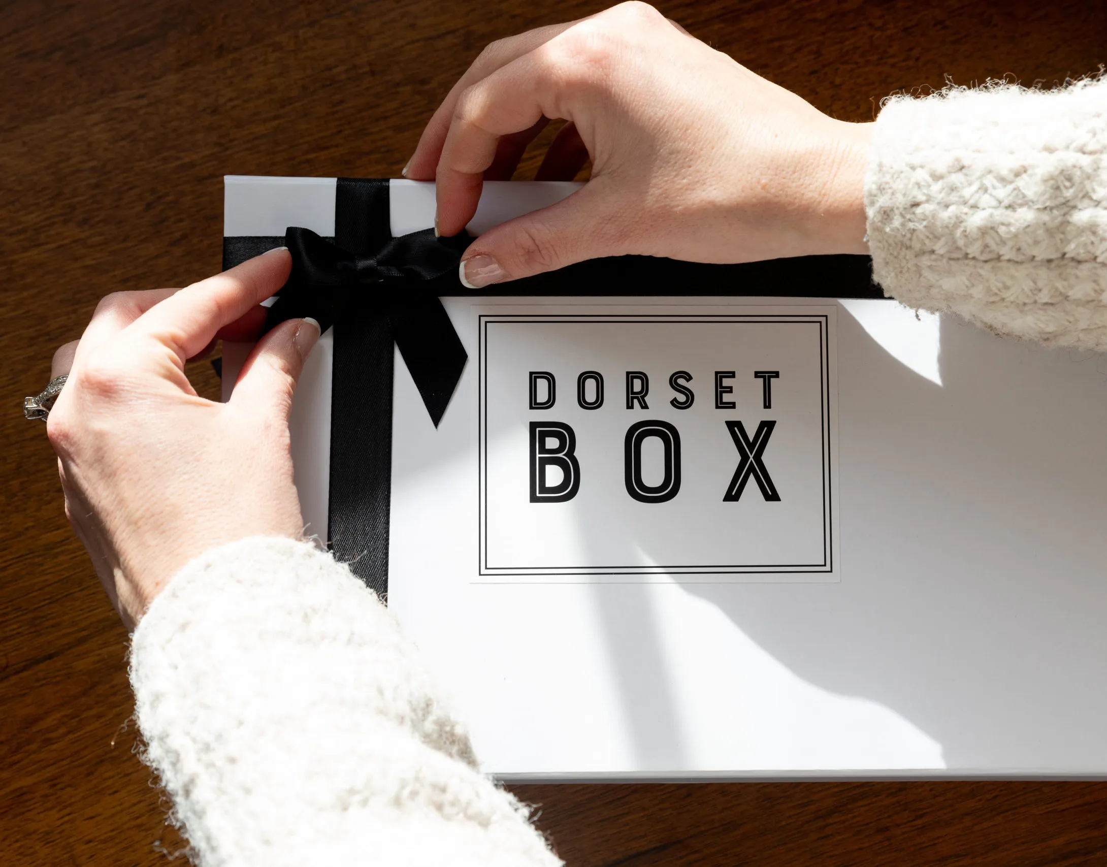 Hands tying ribbon a a Dorset Box Hands tying ribbon a a Dorset Box